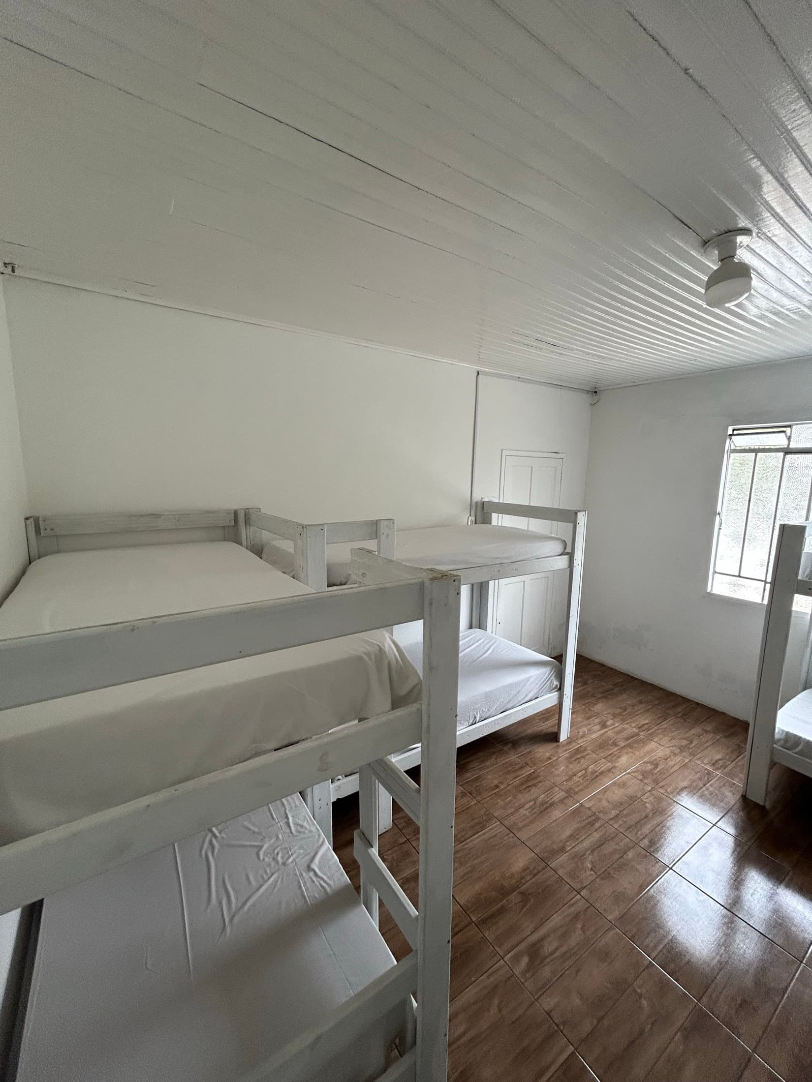 Dormitório da ala nova com camas feitas e piso limpo